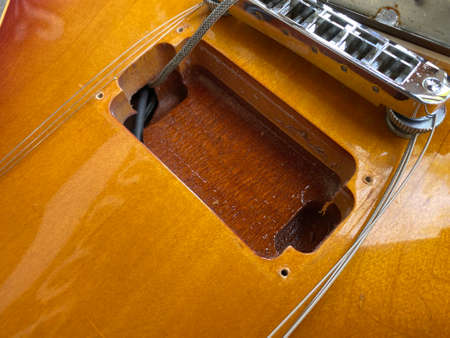 The pickup compartment of the electric guitar opens up to see the inside cherry body color can use for guitar service store or business. wallpaper and background.の写真素材
