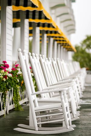Several White Rocking Chairs on Long Porch just waiting for you to come and enjoy on a luxury trip to Mackinac Islandの写真素材