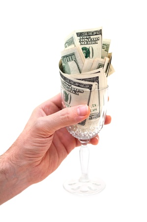 Hand holding glass filled with dollar bills isolated on white backgroundの写真素材