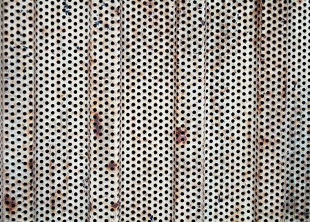 rusty perforated metal sheet backgroundの写真素材