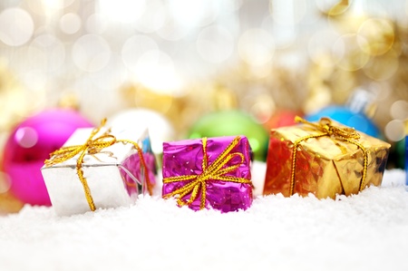  christmas gifts in snow with background of bokeh and lightの写真素材