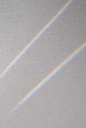 Watercolor paper with overlay of rainbow light and shadow.の写真素材