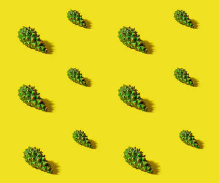 Pattern of Christmas tree young green cones on a bright yellow background. Seamless background.