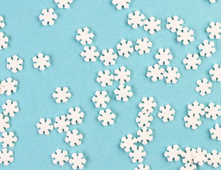 white paper snowflakes are scattered on a blue background. winter holiday background for Christmas and New yearの写真素材