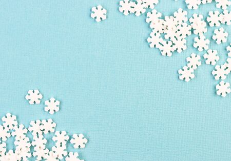 white paper snowflakes are scattered on a blue background. winter holiday background for Christmas and New yearの写真素材