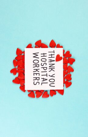 lots of little red hearts and the inscription Thank you to hospital workers on a blue background. concept of gratitude to medical workers during the coronavirus pandemicの写真素材