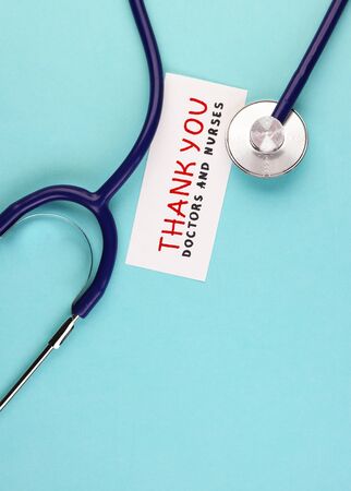 medical stethoscope and the inscription Thank you to doctors and nurses on a blue background. concept of gratitude to medical workers during the coronavirus pandemicの写真素材