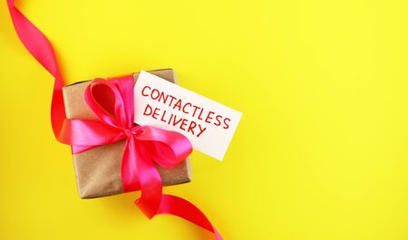 Gift box with pink bow. Contactless delivery during the Covid-19 coronavirus pandemic concept.の写真素材