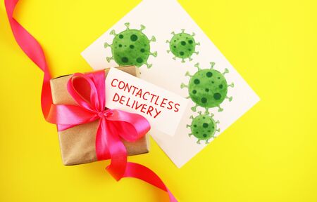 Gift box with pink bow. Contactless delivery during the Covid-19 coronavirus pandemic concept.の写真素材
