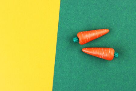 plastic vegetable models on a brown and yellow background, top view. carrot made of plasticineの写真素材