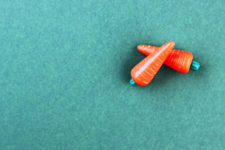 plastic vegetable models on a brown and yellow background, top view. carrot made of plasticineの写真素材