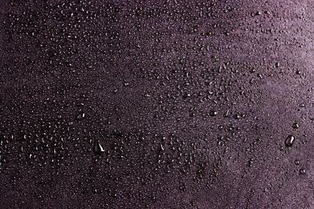 water drops isolated on a black background. black surface with scattered dropsの写真素材