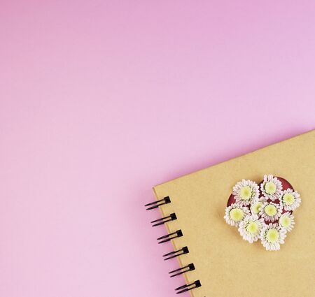 Top view of an office Desk with a Notepad, pen and copy space on a background of pastel colors. notebook with pencil on pink backgroundの写真素材