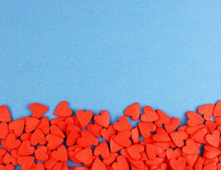 many red hearts are scattered on a blue background, top view. pastel background for Valentine's day and women's holidaysの写真素材