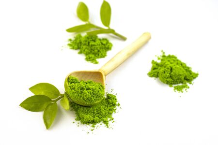 dry green tea powder matcha tea with a wooden spoon and whole leaves, isolate on a white background. Chinese healing soothing tea for health. Eastern grassの写真素材