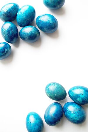 Blue Easter eggs on a white background, top view. holiday eggs are located in the cornersの写真素材