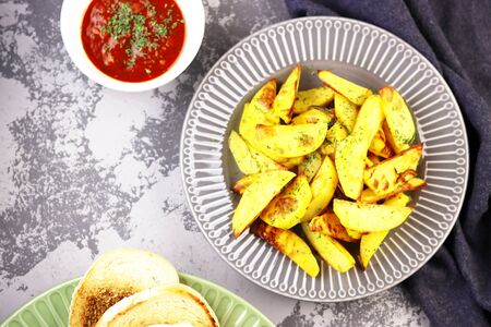 sweet potatoes with greens and ketchup close - up on the table. fried potatoes with tomato sauce top viewの写真素材