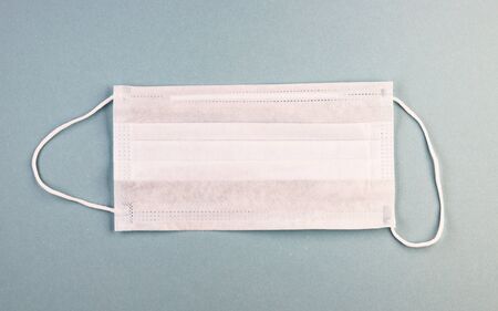 A typical 3-layer surgical mask to cover the mouth and nose. The procedure of the mask against...