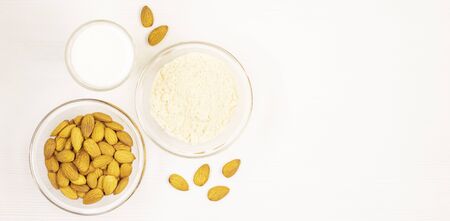 Bowl with dried almonds isolated on a white background. nuts scattered on the table. eco health productの写真素材