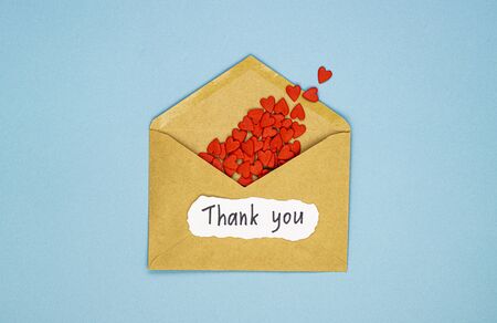 red hearts spilled out of an envelope and the inscription thank you. the concept of gratitude to medical workers, heroes in the fight against diseasesの写真素材