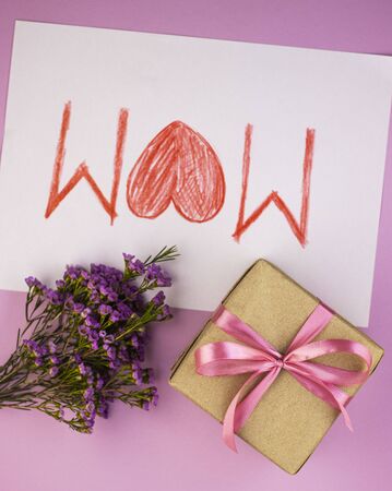 mother's day greeting card, top view. the inscription mother with a big red heart. bouquet of wild flowers with a card and giftの写真素材