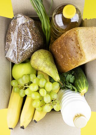 Box of raw fresh fruit with dairy products, top view. grant for the poor, assistance to the elderly, homeless and sickの写真素材
