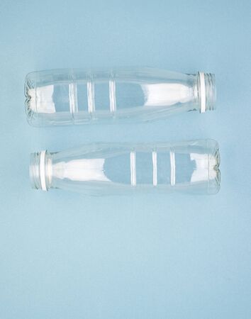 Two empty plastic bottles on a blue background. The concept of encouraging people not to use plastic items to prevent environmental pollution, ecology. The rejection of the plasticの写真素材