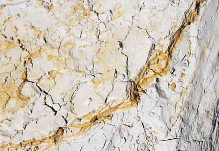 abstract texture of coastal white stone with red stripes for background, close-up. rough, uneven surface of the rock pebblesの写真素材