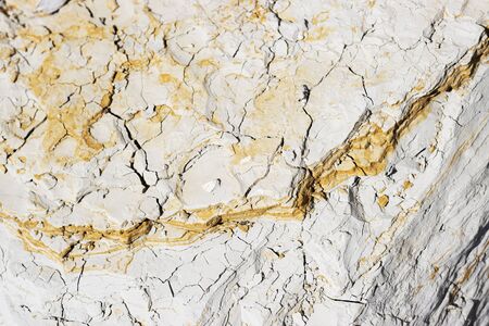 abstract texture of coastal white stone with red stripes for background, close-up. rough, uneven surface of the rock pebblesの写真素材