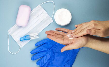 women's medical hands take care of the skin of their hands after removing gloves, top view. moisturizing and nourishing cream for hands damaged by antiseptics and disinfectantsの写真素材