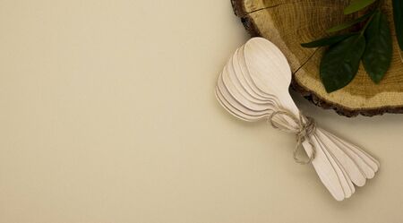 Eco wooden spoons for catering and street fast food on a beige background with a copy space. Cleanliness of the planet, care for nature and the concept of waste disposalの写真素材
