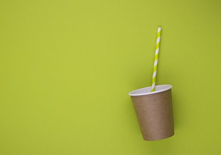 eco tableware and eco containers for drinks coffee and tea with a paper tube on a pleasant green background with space for text. the concept of caring for nature and the environment, waste managementの写真素材