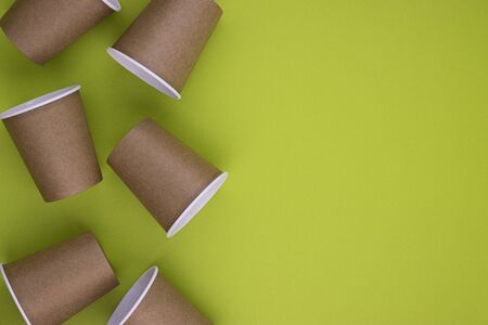 eco tableware and eco containers for drinks coffee and tea with a paper tube on a pleasant green background with space for text. the concept of caring for nature and the environment, waste managementの写真素材