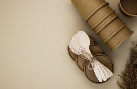 Eco-friendly food packaging and wooden spoons for catering and street fast food on a beige...