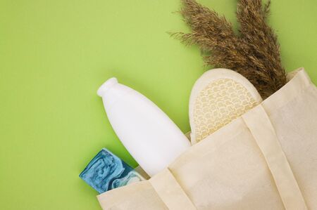eco dishes and eco containers for food and drinks in a linen eco bag on a light green background with a copy space. preserving the cleanliness of the environment, taking care of nature, waste disposalの写真素材