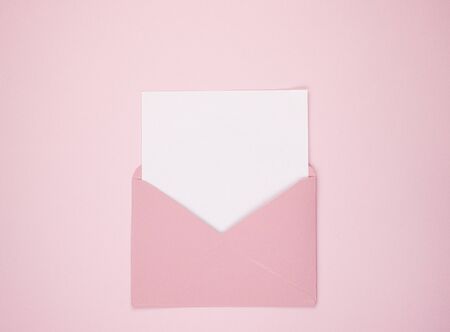 An open pink envelope containing a blank sheet of white paper, space for text. Space for text on a...
