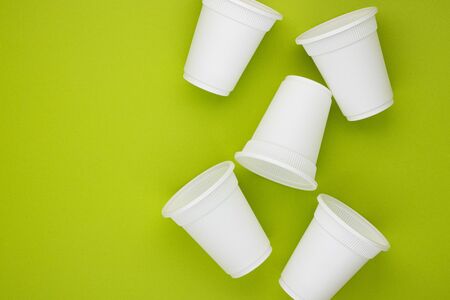 biodegradable beverage containers on a green background, space for text. environmental protection. caring for nature. the rejection of the plasticの写真素材