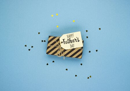 Happy father's Day with gift box, confetti stars on blue background. background for dad's day greetingsの写真素材