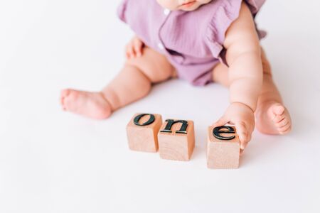 the baby's hands hold square letters. the word one is built from letters. the concept of leadershipの写真素材