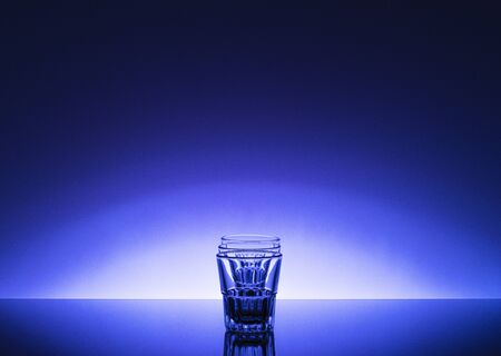 empty vodka glasses with a beautiful blue diffuse background. creative photo for advertisingの写真素材