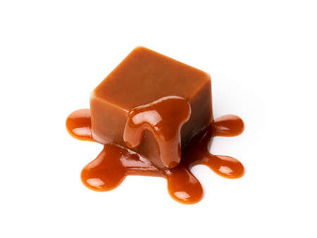 A melting piece of milk chocolate on a white background. sweet liquid caramel close upの写真素材