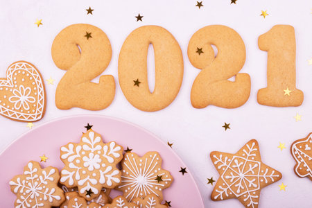 Multi-colored confectionery with sugar sprinkles and gingerbread in the form of numbers 2021 and stars on a white background. 2021 New year and Christmas ginger cookiesの写真素材