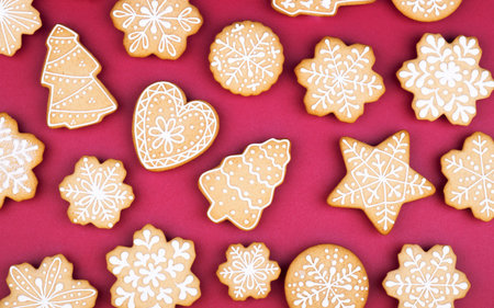 Christmas gingerbread snowflakes and Christmas trees on a dark red background. new year holiday backgroundの写真素材