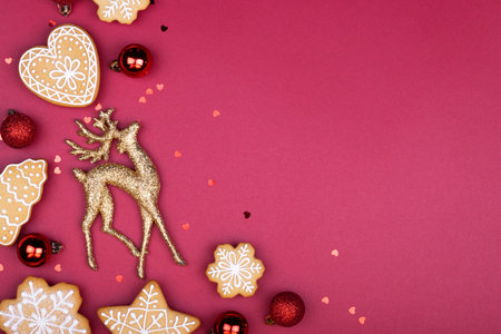 gingerbread snowflakes Golden deer and red Christmas balls on a dark red background with copy space for text. the concept of a holiday, celebration and cooking. new year and Christmas cardの写真素材