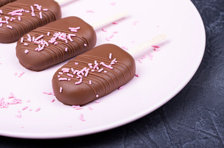 Eskimo ice cream with chocolate on a wooden stick. chocolate ice cream on a plateの写真素材