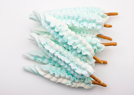delicious sweet meringue on a stick in the shape of a feather. sweet treats for a children's holidayの写真素材