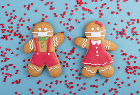 Gingerbread man with a mask on his face on a blue background. Creative gingerbread in the concept of...