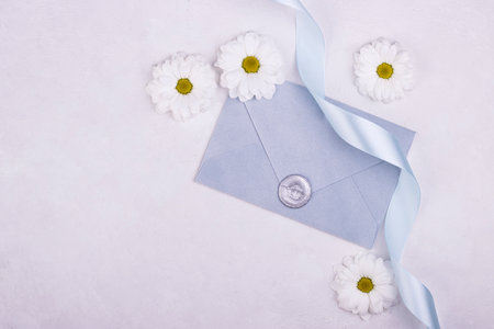 gray paper envelope with a wax seal and scattered white flowers on the background. background for Valentine's day, mother's dayの写真素材