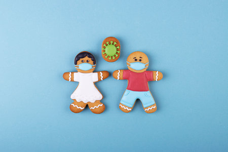 Gingerbread boy and girl in medical masks, gingerbread coronavirus. the concept of the world coronavirus pandemicの写真素材