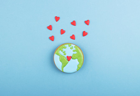 Gingerbread planet earth and lots of little red hearts on blueの写真素材